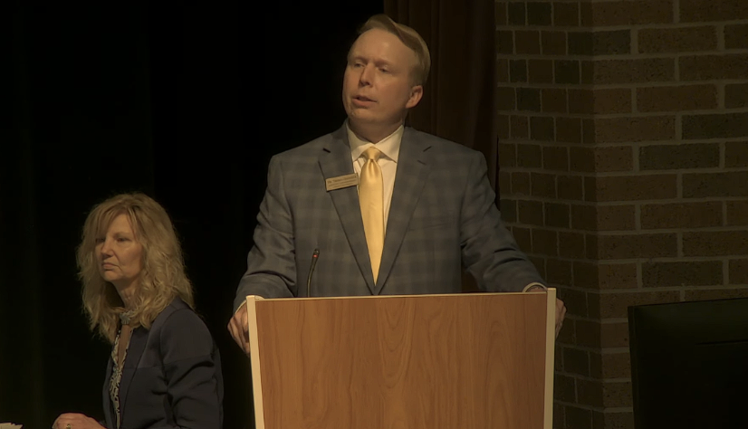 Assistant Superintendent Thomas Oestreich addresses the service award recipients and retirees at the Clay Middle School auditorium. He said it is important to recognize and honor teachers who have spent a lot of time with the district and to have their families watch as well. 
